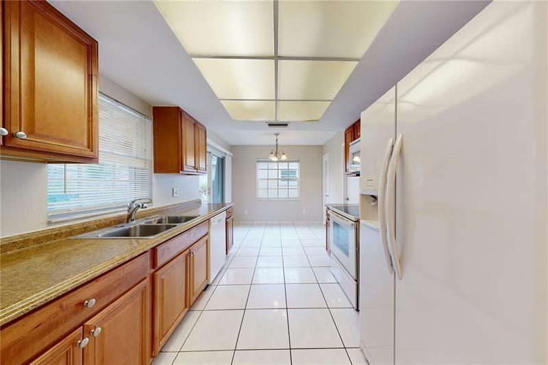 9728 Southwest 3rd Street Boca Raton, FL 33428 - Photo 4 of 7 a kitchen with granite countertop a sink a counter top space and stainless steel appliances