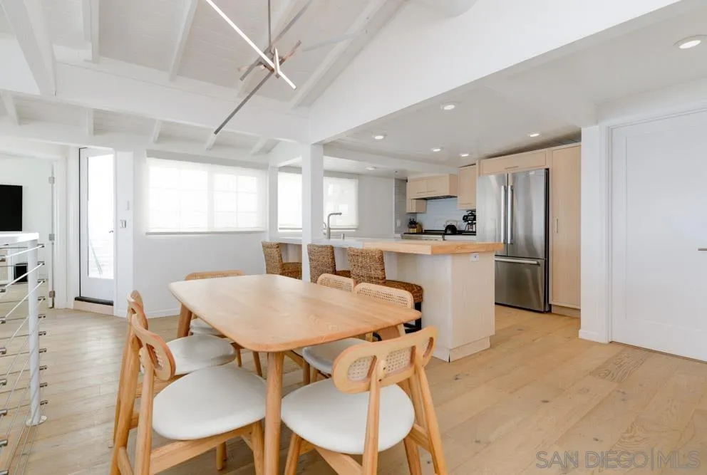 2633 Ocean Street Carlsbad, CA 92008 - Photo 11 of 23 a kitchen with stainless steel appliances kitchen island granite countertop a dining table chairs and a refrigerator