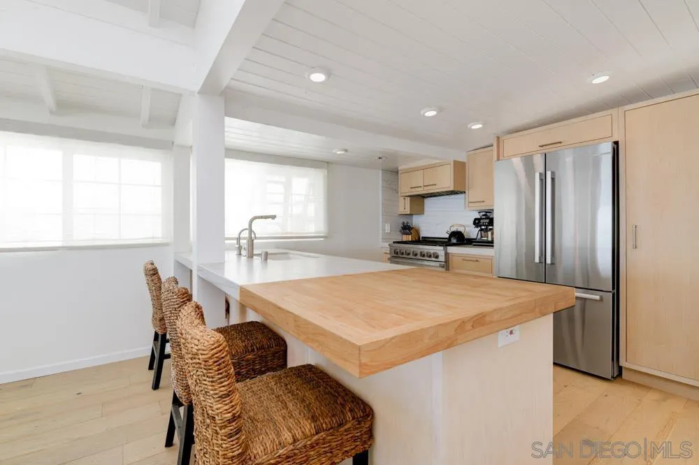 2633 Ocean Street Carlsbad, CA 92008 - Photo 3 of 23 a kitchen with stainless steel appliances a refrigerator a table and chairs