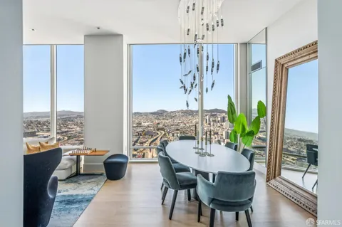 a dining room with furniture potted plants and wooden floor