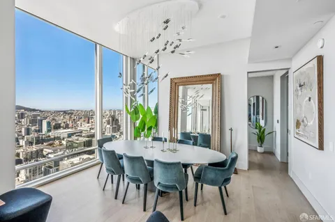 a view of a dining room with furniture and a potted plant