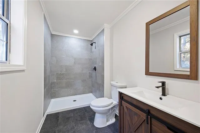 a bathroom with a toilet a sink a mirror and a shower