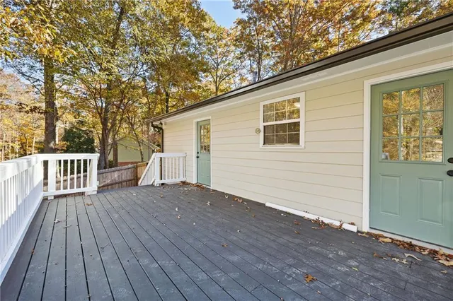 a view of backyard with wooden deck and floor to ceiling window