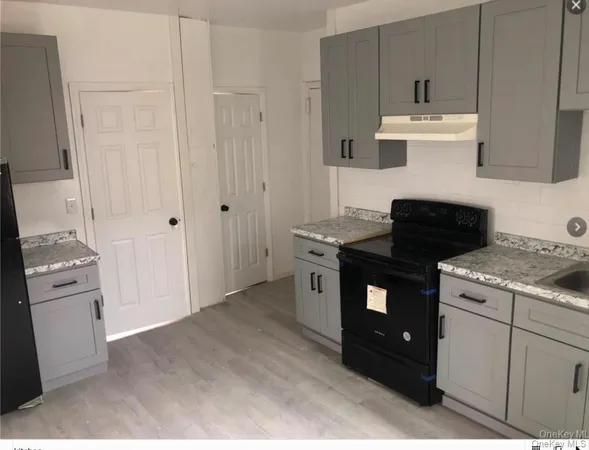 a kitchen with granite countertop white cabinets and white appliances