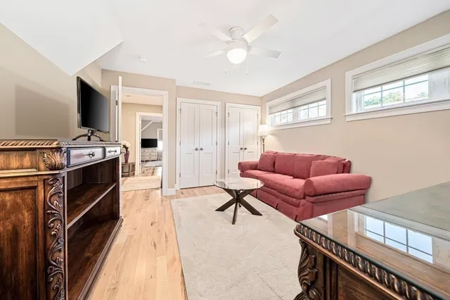 a living room with furniture a flat screen tv and a window