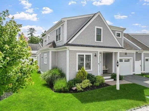 a front view of a house with a garden and plants