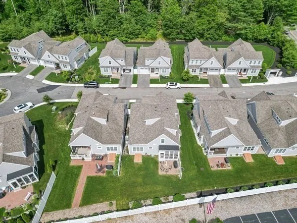 an aerial view of multiple houses with a yard