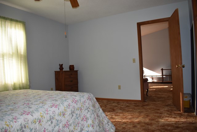135 Taylor Road Gray, GA 31032 - Photo 12 of 28 a bedroom with a bed and a chandelier