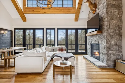 a living room with fireplace furniture and a floor to ceiling window