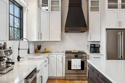 a kitchen with stainless steel appliances a stove a sink a refrigerator and cabinets