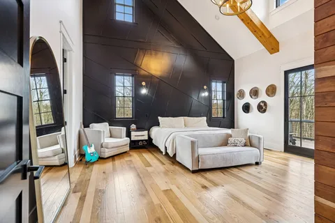 a spacious bedroom with a bed couch and a window