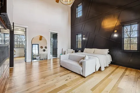a spacious bedroom with a bed lamp closet and window