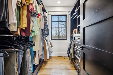 a view of walk in closet with clothes and shoes