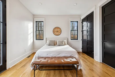a bed sitting in a bedroom next to a window and wooden floor