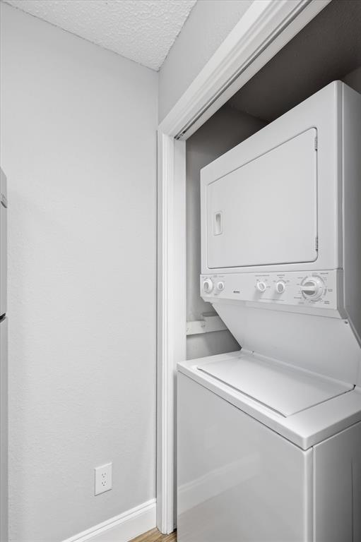 5550 Spring Valley Road, Unit A31 Dallas, TX 75254 - Photo 8 of 24 Dedicated laundry closet featuring a white stackable washer and dryer unit