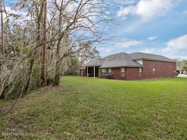 4445 Mandarin Ridge Court Jacksonville, FL 32258 - Photo 29 of 33 a front view of a house with a garden and yard