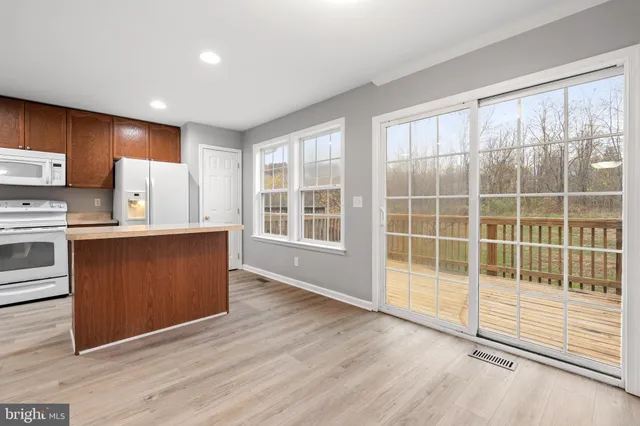 a view of kitchen with wooden floor and electronic appliances