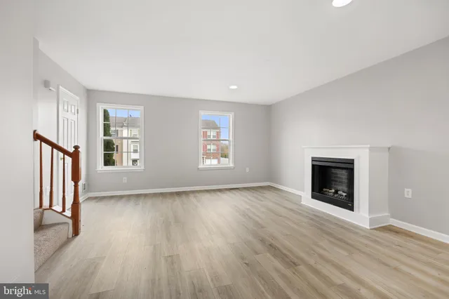 an empty room with windows and a fireplace
