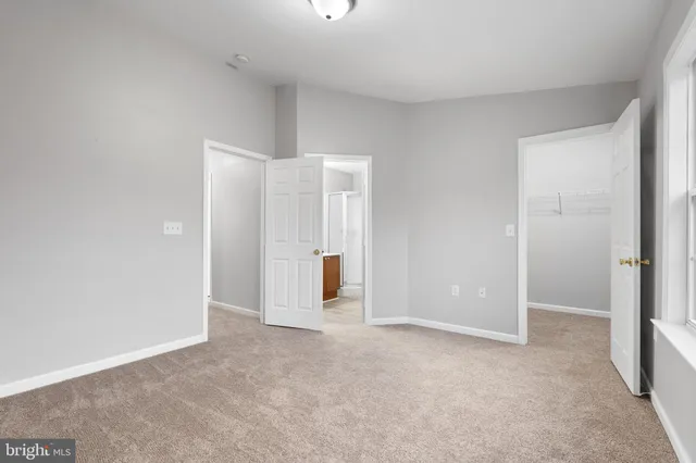 an empty room with closet and mirror