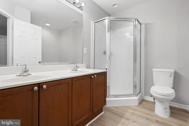 a bathroom with a double vanity sink toilet and a mirror