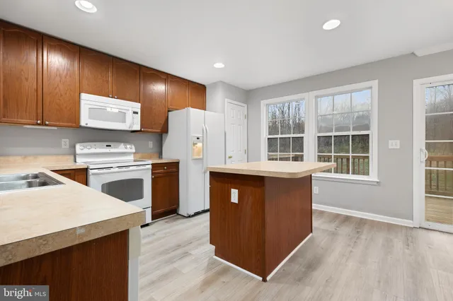 a kitchen with a refrigerator and a stove top oven