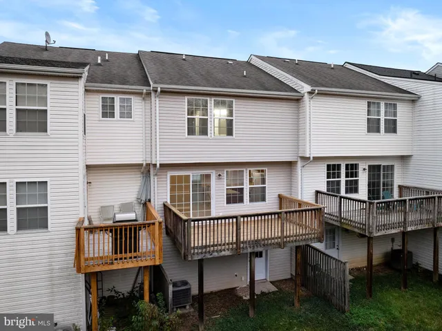 a view of a house with wooden deck and furniture