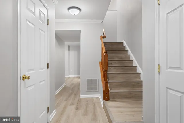 a view of a hallway with wooden floor and entryway