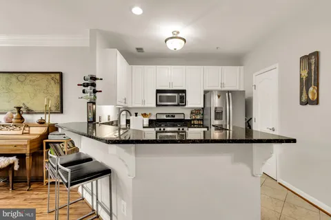 a kitchen with stainless steel appliances granite countertop a sink and a stove