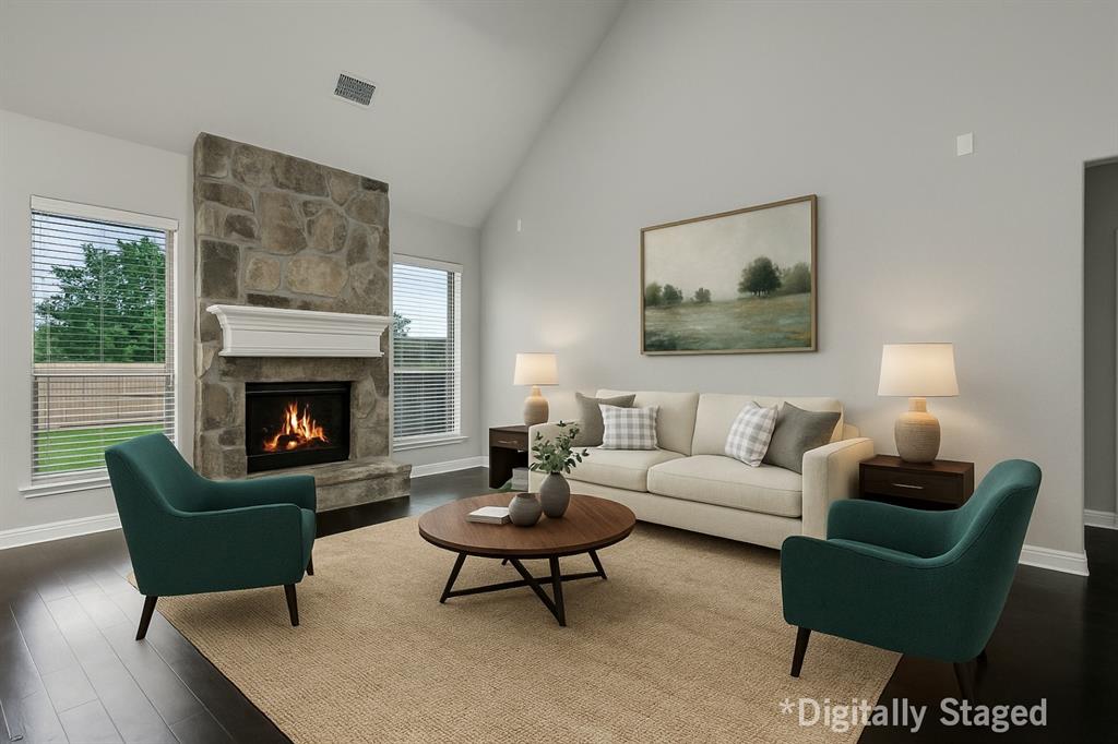 925 Spring Falls Drive McKinney, TX 75071 - Photo 11 of 40 a living room with furniture a rug a lamp and a fireplace