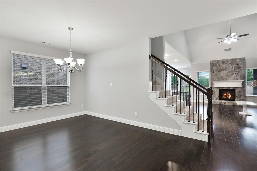 925 Spring Falls Drive McKinney, TX 75071 - Photo 15 of 40 a view of a livingroom with wooden floor staircase and a kitchen