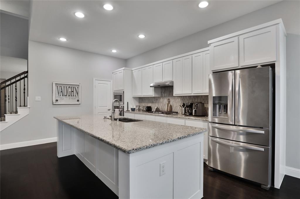 925 Spring Falls Drive McKinney, TX 75071 - Photo 16 of 40 a kitchen with kitchen island a sink stainless steel appliances and refrigerator