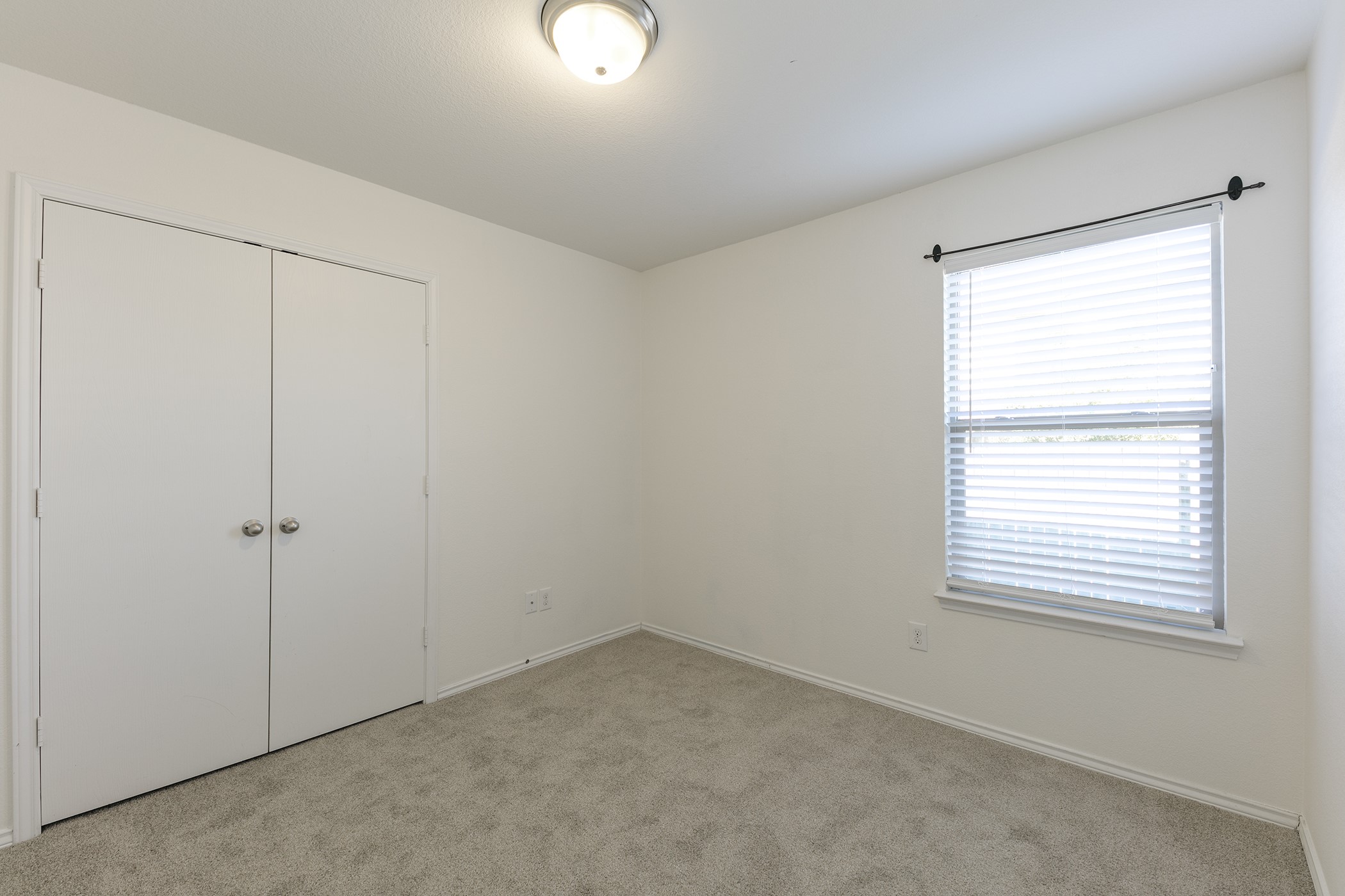 1141 Renaissance Trail Round Rock, TX 78665 - Photo 13 of 23 A well-lit bedroom with fresh carpeting and a large window, ready for personalization.