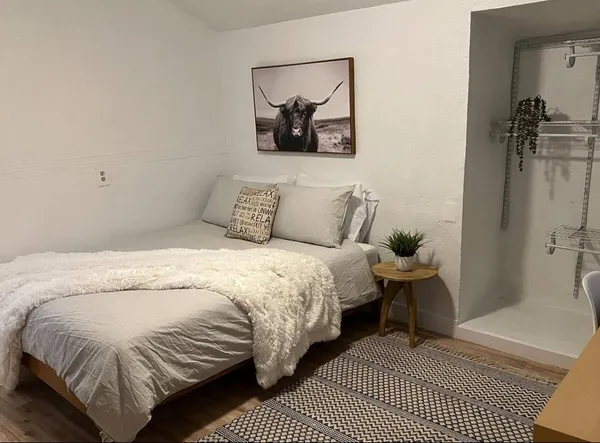 a bedroom with a bed and a painting on the wall
