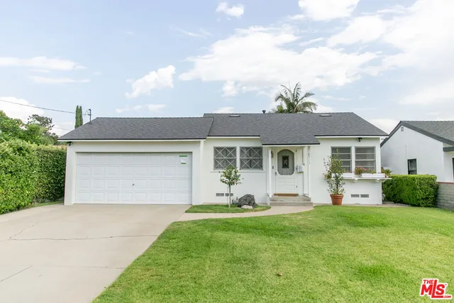 a front view of a house with a garden and plants