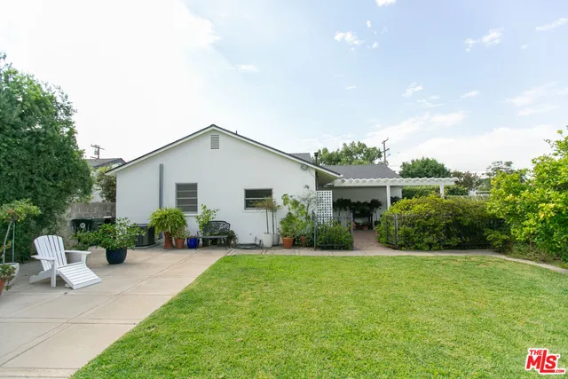 a view of a house with backyard and sitting area