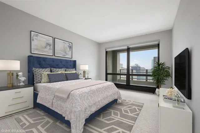 a bedroom with a large bed and a flat tv screen on dresser