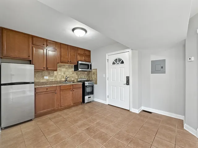 a kitchen with a refrigerator sink and cabinets