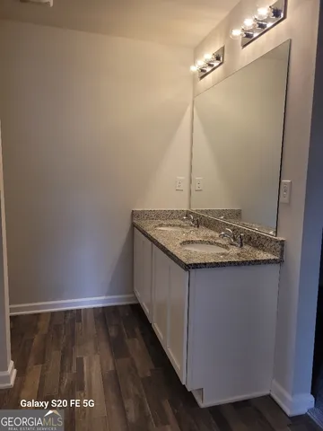 a bathroom with a granite countertop sink and a mirror