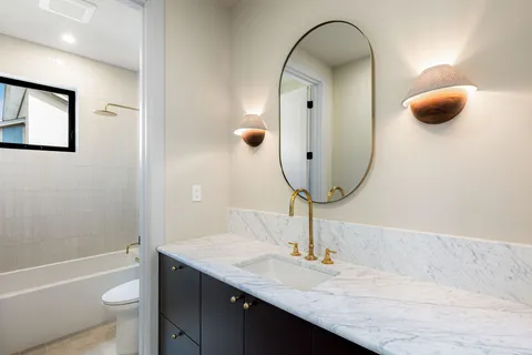 a bathroom with a granite countertop sink and a mirror