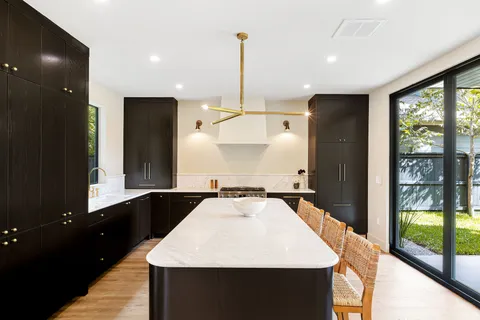 a large white kitchen with a large window