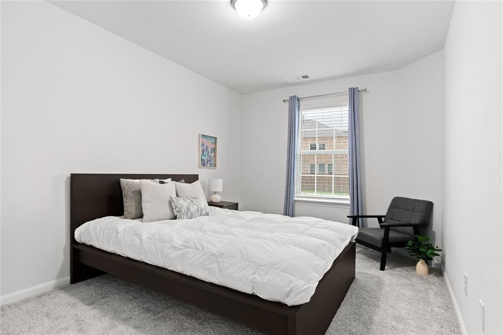 2070 Placerville Street Forney, TX 75126 - Photo 24 of 36 a bedroom with a bed a table and a chair