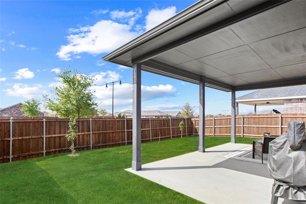 2070 Placerville Street Forney, TX 75126 - Photo 34 of 36 a view of a backyard with couches under an umbrella