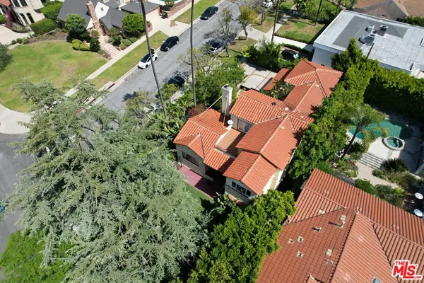 an aerial view of residential houses with outdoor space and trees