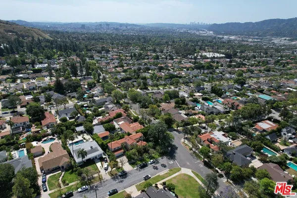 an aerial view of residential houses with outdoor space and mountain view
