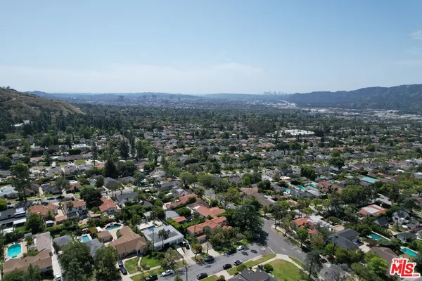 an aerial view of a house with a yard swimming pool and outdoor seating