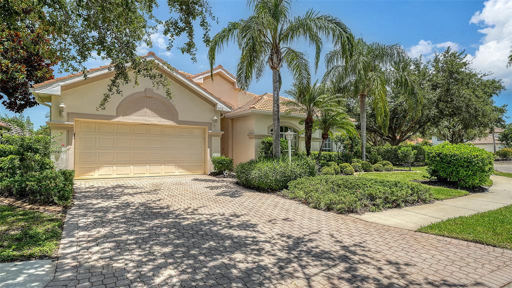 7717 US Open Loop Lakewood Ranch, FL 34202 - Photo 2 of 95 a view of a house with a yard and palm trees