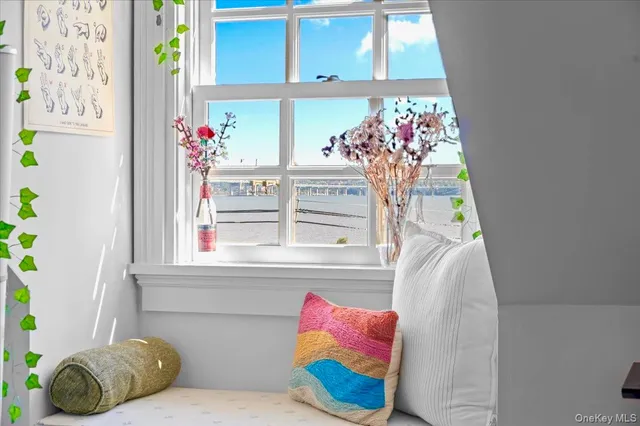 a bedroom with bed and a flat tv screen next to a window