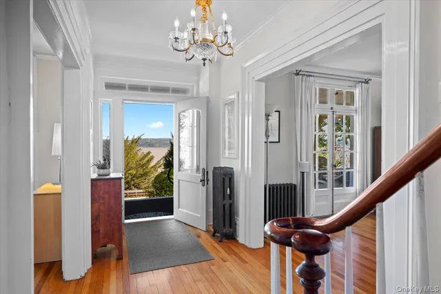 a view of a hallway with wooden floor and staircase