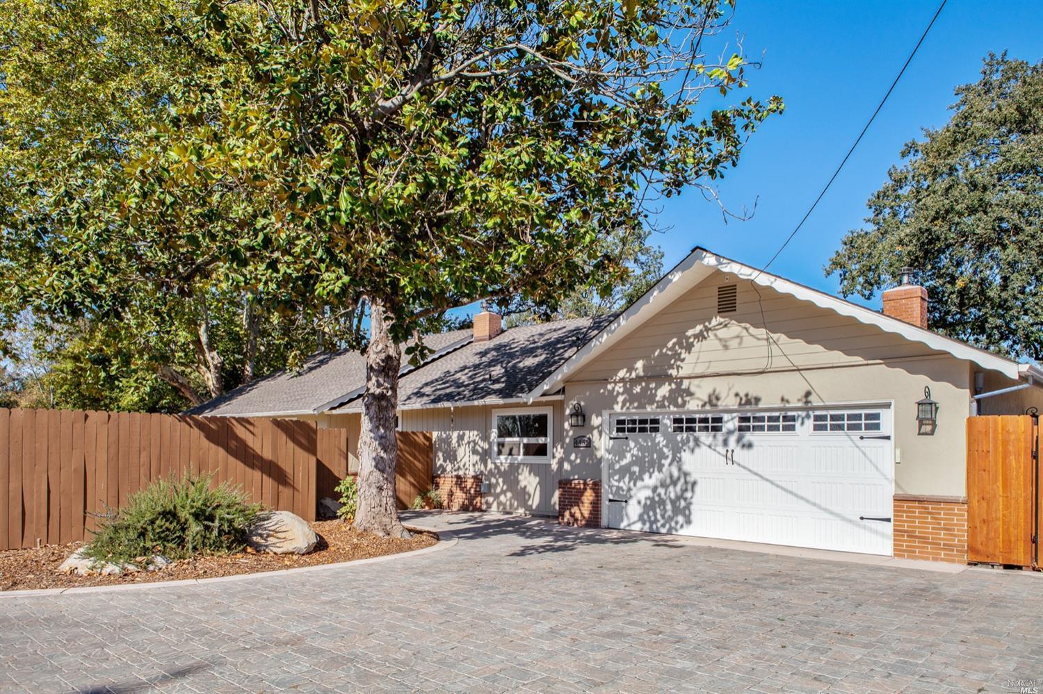 4455 Hall Road Santa Rosa, CA 95401 - Photo 1 of 1 a view of a white house with a large tree and wooden fence