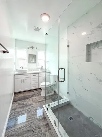 a bathroom with a double vanity sink a mirror and a shower